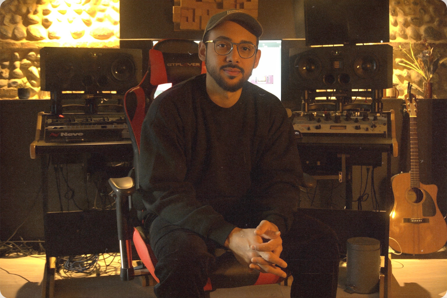 DAMIAN no estúdio, entre monitores e equipamentos de áudio.